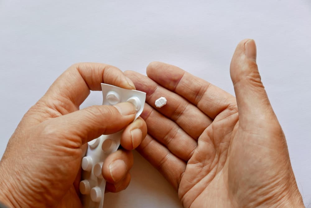 Person taking pills out from packet