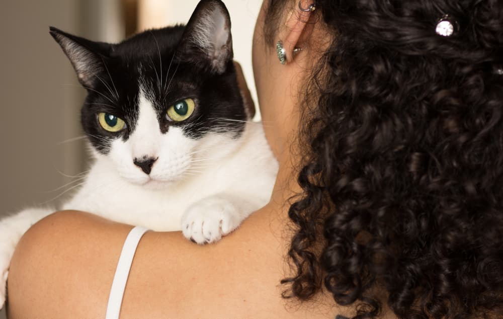 Woman holding cat on shoulder