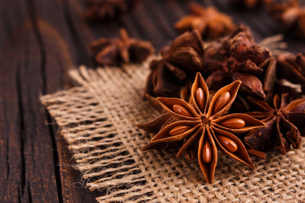 Anise stars on a woven backdrop on a table