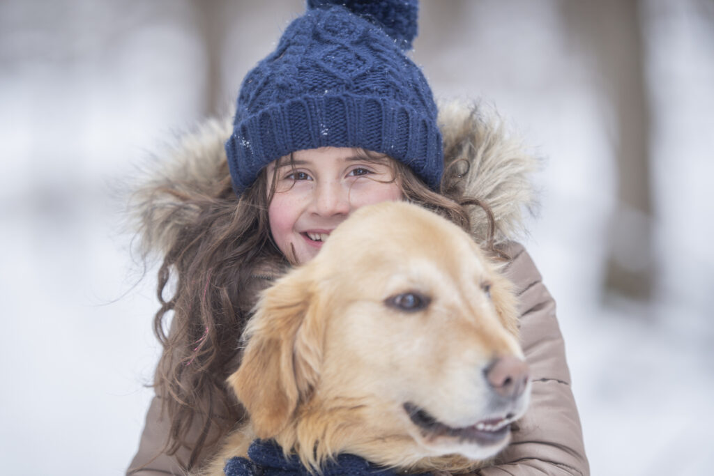 Girl hugging a dog in the snow